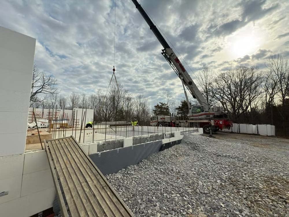 General contractor Georgetown KY installing insulated concrete forms (ICF) at a commercial construction site with crane placement and foundation work in progress.